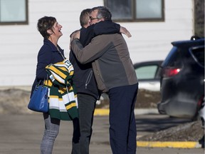 Russell, left, and Raelene Herold, parents of Adam Herold, hug with Toby Boulet, father of Logan Boulet, outside the Kerry Vickar Centre on March 22, 2019.