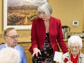 Federal employment minister Patty Hajdu speaks with Rick Boldt, left, and Frida Wills at a campaign-style event at a Saskatoon seniors' home.