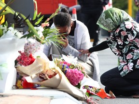 Locals lay flowers in tribute to those killed and injured at Deans Avenue near the Al Noor Mosque on March 16, 2019 in Christchurch, New Zealand
