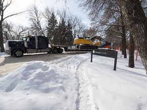 A semi truck, hauling a track hoe, exits the construction site of the new Brandt building in Wascana Park just off Broad Street.