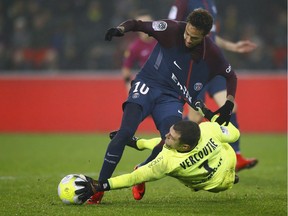 PSG's Neymar, left, challenges for the ball with Caen's goalkeeper Remy Vercoutre during the French League One soccer match between Paris Saint Germain and Caen, at the Parc des Princes stadium in Paris, France, Wednesday, Dec. 20, 2017.
