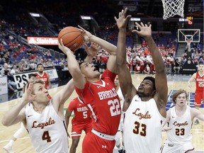 Bradley's Ja'Shon Henry (22) heads to the basket as Loyola of Chicago's Bruno Skokna (4), Franklin Agunanne (33) and Cooper Kaifes (23) defend during the first half of an NCAA college basketball game in the semifinal round of the Missouri Valley Conference tournament, Saturday, March 9, 2019, in St. Louis.