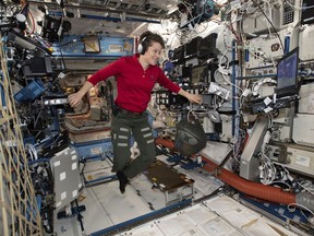 In this Jan. 18, 2019 photo made available by NASA, Flight Engineer Anne McClain looks at a laptop computer screen inside the U.S. Destiny laboratory module of the International Space Station. McClain was supposed to participate in a spacewalk Friday, March 29, 2019 with newly arrived Christina Koch. But McClain pulled herself from the lineup because there's not enough time to get two mediums suits ready. Koch will go out with a male crewmate. (NASA via AP)