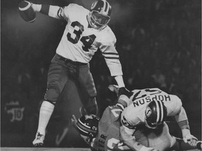 Jim Hopson, top right, flattens the B.C. Lions' Danny Dever to clear a path for Saskatchewan Roughriders fullback George Reed during a Sept. 7, 1974 game at Vancouver's Empire Stadium.