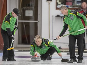 Team Saskatchewan Skip Brad Heidt throws, as Second Randy Graham, left, and Third Terry Marteniuk prepare to sweep against Team North West Territories during the Canadian masters curling championships at the Nutana Curling Club in Saskatoon, SK on Tuesday, April 2, 2019.