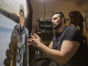 Artist Jord Sasakamoose, one of over 70 contributors to this year's 10x10 Art Project, works on a painting of his relative Fred Sasakamoose, a former NHL player and Chief, in Saskatoon on Saturday, April 13, 2019.