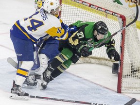 Saskatoon Blades forward Chase Wouters checks Prince Albert Raiders forward Parker Kelly during the first period of WHL playoff action at SaskTel Centre in Saskatoon on Sunday, April 14, 2019.