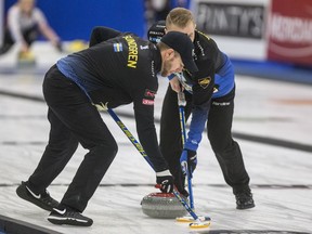 B.C.'s Jim Cotter, subbing on Niklas Edin's Swedish team at this week's Champions Cup, sweeps while wearing the jacket of lead Christoffer Sundgren.