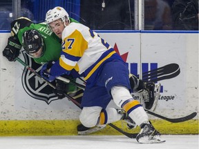 Saskatoon Blades defence Nolan Kneen and Prince Albert Raiders forward Parker Kelly battle for the puck during first period WHL action at SaskTel Centre in Saskatoon, SK on Thursday, December 27, 2018.