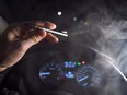 In this photo illustration, smoke from a cannabis oil vaporizer is seen as the driver is behind the wheel of a car in North Vancouver, B.C., on November 14, 2018. Canadian police say they haven't been busting many more stoned drivers six months after legalization and continue to prioritize investigative resources toward more deadly drugs, but are reminding drivers to keep cannabis out of reach.