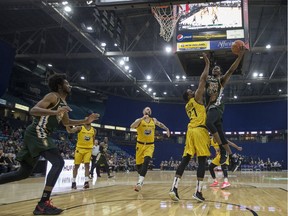 Saskatchewan Rattlers forward Tavrion Dawson reaches to make a basket over Hamilton Honey Badgers center Mike Fraser during the game at SaskTel Centre in Saskatoon on Thursday, May 16, 2019.