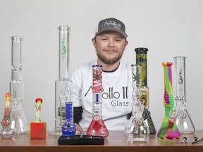 Greg Clark, owner of the online head shop Apollo 11 Glass, sits for a photograph with some of his products at the Star Phoenix studio in Saskatoon, SK on Friday, May 17, 2019.