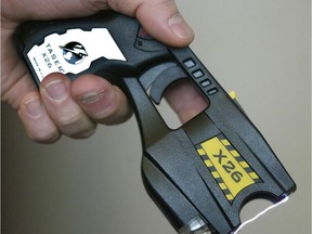 A police officer displays a Taser X26 conducted energy weapon.