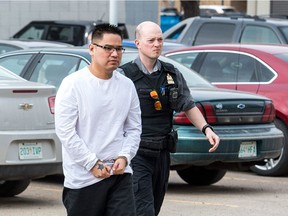 Elwin Michael Goodpipe, left, is escorted into Regina's Court of Queen's Bench.