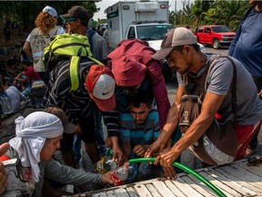 Migrants collect water while walking north through the Mexican state of Chiapas, Mexico, near the town of Huixtla, April 18, 2019. A steady stream of migrant caravans in recent months has taxed local resources and the patience of residents who are turning their ire on Mexico's president. (Brett Gundlock/The New York Times) ORG XMIT: XNYT2