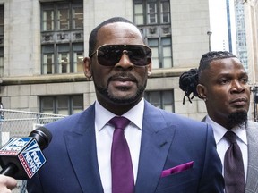 This March 13, 2019 file photo shows R. Kelly and his publicist Darryll Johnson, right, leaving The Daley Center after an appearance in court for Kelly's child support case in Chicago. Prosecutors in Chicago have charged Kelly with 11 new sex assault charges, some that are more serious than those first filed against him in February. The Chicago Sun-Times reported Thursday, May 30, on its website that the charges include counts that carry a potential sentence of up to 30 years in prison. The charges say the alleged offenses happened in 2010. (Ashlee Rezin/Chicago Sun-Times via AP, File) ORG XMIT: ILCHS306