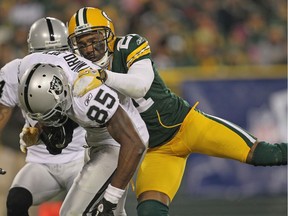 GREEN BAY, WI - DECEMBER 11: Darrius Heyward-Bey #85 of the Oakland Raiders is tackled by Charles Woodson #21 of the Green Bay Packers at Lambeau Field on December 11, 2011 in Green Bay, Wisconsin. The Packers defeated the Raiders 46-16.