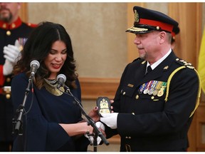 Saskatoon board of police commissioners chair Darlene Brander presents Troy Cooper, Saskatoon's newest police chief, with his new badge after being officially sworn in by QueenÕs Bench Justice Gerald Allbright in city council chambers in Saskatoon on February 28, 2018.