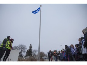 Students from St. Michael Community School (R) sing during a Métis flag-raising on Nov. 16, 2018.