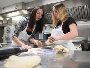 Brittany Dobranski, left, and Athena McEwen, sister to Athan McEwen, make cookies together at the Conexus Arts Centre. Friends and Family members of Athan's are making 1,200 memorial cookies to pass out to students at Dr. Martin LeBoldus High School, his former high school.