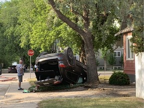 A man looks at a vehicle that was involved in a two vehicle rollover collision at the corner of 8th Street and Eastlake Avenue in Saskatoon on June 13, 2019. (Amanda Short/ Saskatoon StarPhoenix)
