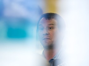 Jeremy Bohmann, (seen though a window with signs) who was hospitalized with a herniated disc and during his time in the hospital was given hydromorphone, speak to media during a news conference regarding concerns with overprescribing opioids at the NDP Riversdale Constituency Office in Saskatoon, SK on Tuesday, June 18, 2019.