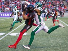 Seth Coate, left, of the Ottawa Redblacks makes a catch for a 43-yard gain despite tight coverage by the Saskatchewan Roughriders' Nick Marshall on Thursday.