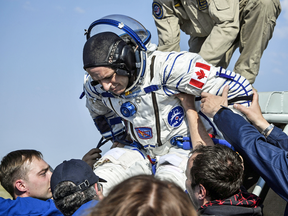 Ground personnel help Canadian astronaut David Saint-Jacques out of the Soyuz MS-11 capsule shortly after landing in Kazakhstan on June 25, 2019, after spending 204 days on the International Space Station.