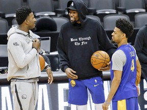 Golden State Warriors' Kevin Durant (centre) makes an appearance at practice with teammate Jordan Bell (R) and Quinn Cook PG (4) in Toronto on Saturday June 1, 2019.