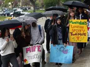 Participants in the Make Mife Free in MB rally at the Manitoba Legislative Building stand in the rain during a speech on Mon., June 3, 2019. The rally turned into more of a celebration after the province announced over the weekend that it would provide universal access to abortion pill Mifegymiso, which was previously available free only at clinics in Winnipeg and Brandon that offer surgical abortions. Advocates will now turn attention to pharmacies stocking Mife, and expanding who can prescribe it.  (Kevin King / Postmedia Network)