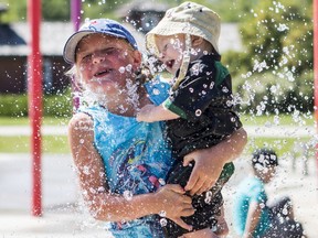 Brielle Materi plays with her cousin, Thunder Gaida, in the spray park at Kinsmen Park in Saskatoon, Sask. on Tuesday, July 23, 2019.