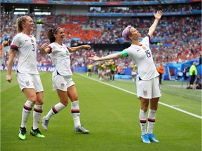 Megan Rapinoe of the USA celebrates with teammates Alex Morgan and Samantha Mewis after scoring her team's first goal during the 2019 FIFA Women's World Cup France Final match between The United States of America and The Netherlands at Stade de Lyon on July 07, 2019 in Lyon, France.