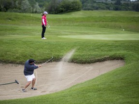 SASKATOON,SK--JULY 05/2019-0706 Sports Women's Golf- SaskatoonÕs Kathy Ziglo hits out of the bunker, while SaskatoonÕs Carla Odnokon, the defending champion, looks on during the Saskatchewan Amateur Women's Golf Championship at Moon Lake golf course near Saskatoon, SK on Friday, July 5, 2019.