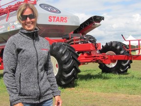 Carmen Hession stands in front of an air cart made from donated parts and assembled by employees at Morris Industries. The machine was sold off at the Ag In Motion trade show with funds raised going to STARS Air Ambulance.