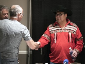 Canadian Tire east owner Francois Brien shakes hands with Kamao Cappo after a press conference held by the Saskatchewan Human Rights Commission as a resolution was announced about a complaint from July 2017.