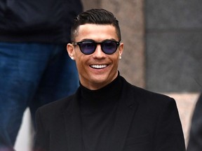 In this file photo taken on January 22, 2019 Juventus' forward and former Real Madrid player Cristiano Ronaldo smiles as he leaves after attending a court hearing for tax evasion in Madrid . - Cristiano Ronaldo will not face rape charges in Nevada, prosecutors said on July 22, 2019.