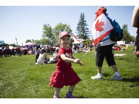 Catherine Dangle waves a flag during the Canada Day celebrations at Diefenbaker Park in Saskatoon, SK on Monday, July 1, 2019.