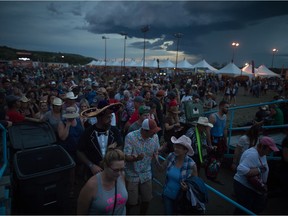 Fans leave the main stage area after being asked to take cover on account of lighting during the Country Thunder music festival.