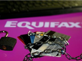 Credit cards, a chain and an open padlock is seen in front of displayed Equifax logo in this illustration taken September 8, 2017.