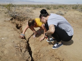 Ridgecrest residents inspect a recent fault rupture following two large earthquakes in the area on July 7, 2019 near Ridgecrest, California. (Photo by Mario Tama/Getty Images)