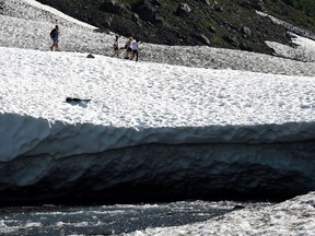 People hike on the Byron Glacier on July 4, 2019 near Portage Lake in Girdwood, Alaska. Alaska is bracing for record warm temperatures and dry conditions in parts of the state.