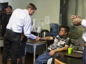 Mayor Charlie Clark shakes hands with Ralph Bird, seated, in the Complex Needs Wing of the Lighthouse.  Community stakeholders and partners were invited to tour the facilities in Saskatoon, Sask. on Wednesday, July 31, 2019.