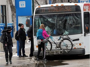 A transit rider walks her bike through the bus mall after removing it from the front of the bike carrier on the bus