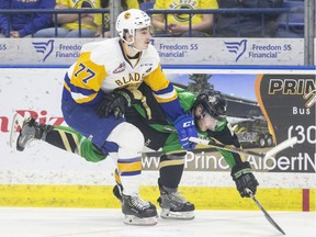 Saskatoon Blades forward Kirby Dach and Prince Albert Raiders defence Brayden Pachal battle for the puck during the second period of WHL playoff action at SaskTel Centre in Saskatoon, SK on Sunday, April 14, 2019.