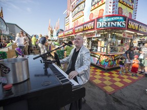 Terry Hoknes performs on his Strolling Piano during the Mardi Gras parade at the Saskatoon Ex in Saskatoon, SK on Wednesday, August 7, 2019.