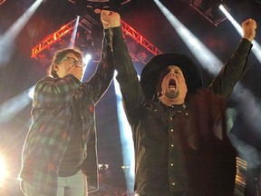 Camille Baragar (left) shares the stage with Garth Brooks after finishing his hit song Standing Outside the Fire at Mosaic Stadium Saturday. Photo courtesy Connie Baragar
