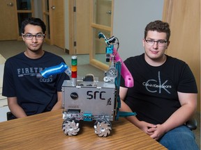 Danish Hasan, left, and Karim Ait-Allaoua sit with their competition robot in an office space on Research Drive. The pair will be taking their robot to Russia, where they will compete in an international skills competition.