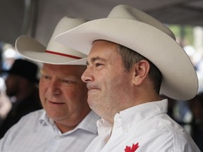 Premiers Jason Kenney, right, of Alberta, and Doug Ford, of Ontario, attend the Premier's Stampede Breakfast in Calgary, Monday, July 8, 2019. Anti-carbon tax governments in Alberta and Saskatchewan say they have no plans to follow Ontario's lead and force gas stations to put anti-carbon tax stickers on their pumps.