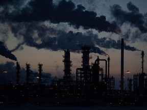 Emissions from the refinery rise into the sky at dusk on a winter evening.