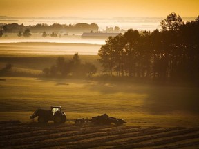 A farm tractor and baler sit in a hay field on a misty morning near Cremona, Alta., Tuesday, Aug. 30, 2016. Canadian farmers are looking to more sustainable farming techniques like capturing carbon in the soil as the warnings grow louder that our food supplies are at risk from climate change and land degradation. Elections Canada says whether discussing the veracity of climate change becomes a partisan issue for third parties during the election will be decided on a case-by-case basis and only if it receives complaints.